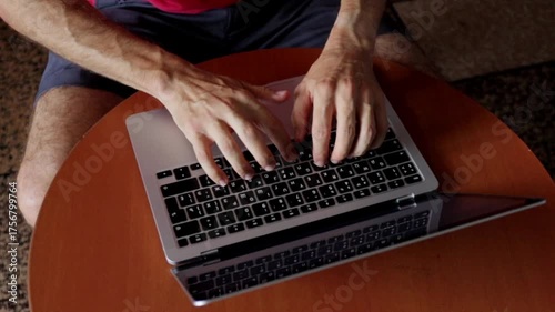 Relaxed work setting, Man using laptop comfortably indoors, Casual work activities within cozy room environment, Person performing work tasks on laptop in comfortable