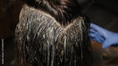 Watch as hair color is applied skillfully in a serene salon. The stylist carefully sections and colors the hair for a fresh new look.