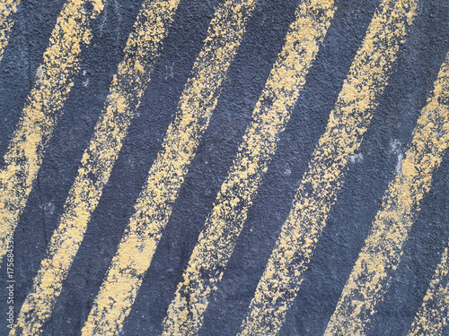 Textured Pavement with Distinct Yellow and Dark Gray Stripes in Urban Setting