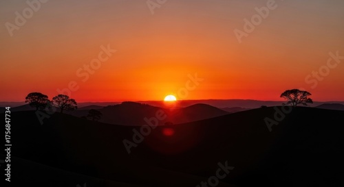 Dramatic sunset casting long shadows over rolling hills, creating a serene and picturesque landscape
