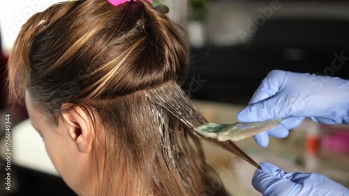 A professional stylist applies color to hair using careful techniques in a vibrant salon. The process highlights steps for achieving beautiful results.