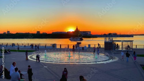 NIZHNY NOVGOROD, RUSSIA - MAY 20, 2024: View from the Nizhnevolzhskaya Embankment at the Oka River. The Alexander Nevsky Cathedral and the Stadium at the lower city in the background, in sunset hues