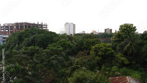 Konstfotografi Urban landscape with lush green trees and unfinished construction site in the ba