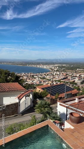 View on Mediterranean sea bay in Spain. Beautiful Luxury villas with swimming pool, tilled rooftops with Solar electric batteries, cell panels of white houses in beach touristic town. 