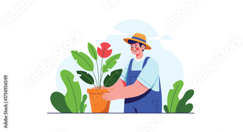 A person wearing a straw hat and blue overalls carefully holds a potted plant.