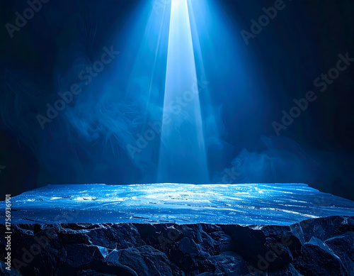 A dramatic blue spotlight illuminates a textured, rocky platform against a smoky, dark background