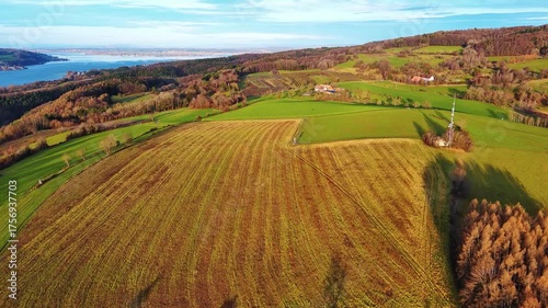 Agricultural meadows, spring forests and a small village on the banks of the river Rhine with hills in the background
