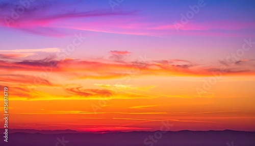 Stunning vibrant sunset paints the sky with fiery oranges, pinks, and purples over silhouetted mountains, creating a dramatic and breathtaking natural spectacle.