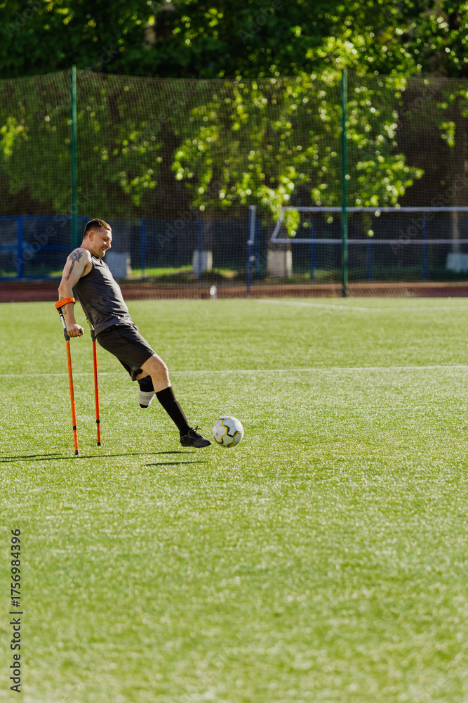 Obraz premium A man hits a ball while leaning on crutches