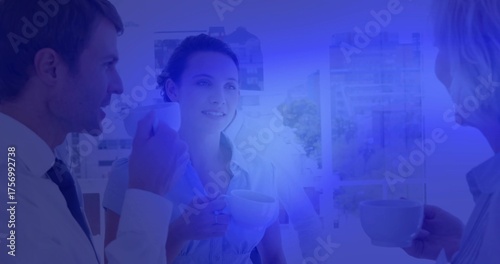 Standing colleagues in business attire sipping coffee from ceramic cups by large window on break