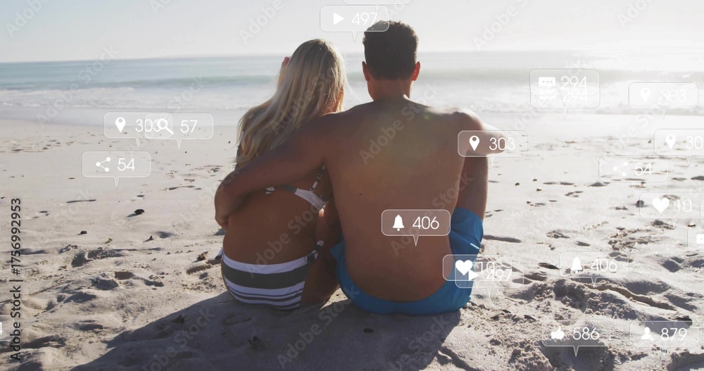 Naklejka premium Sitting couple wearing swimwear embracing, watching sea on sandy beach, with social media icons