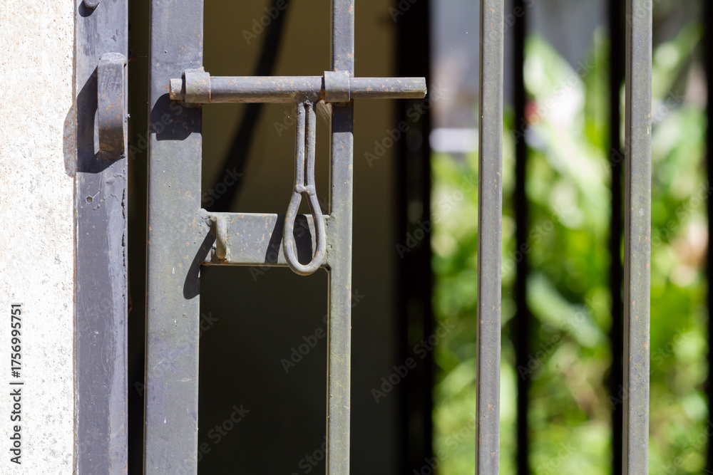 Fototapeta premium Rusty Metal Gate Lock Latch Close-Up – Old Iron Door Mechanism with Vintage Industrial Texture Outdoors