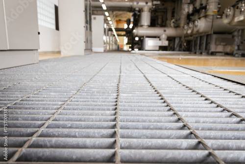 Canvas Print Close-up view of industrial steel floor grating inside a power plant facility, d