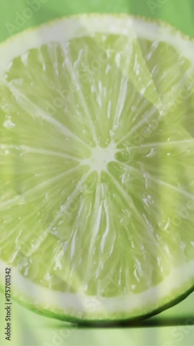 Composition of halved lime and grass on green background