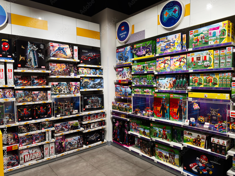 Fototapeta premium Colorful lego sets and Marvel Minecraft toy boxes on bright showroom shelves in a retail store