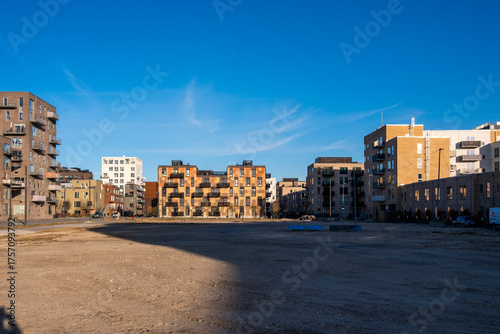 Urban square surrounded by new residential buildings showing open civic space modern design and future oriented planning principles in Orestad Copenhagen