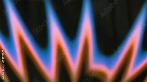 Close-up of a gas stove burner with blue and orange flames. Abstract soft-focus shot of flickering fire. Energy and heat concept