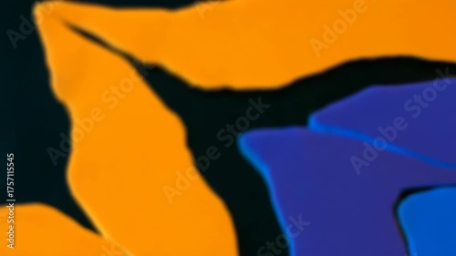 Abstract animated background with fluid morphing shapes. Vibrant orange and blue colors flow on a dark backdrop. Modern soft focus motion graphics