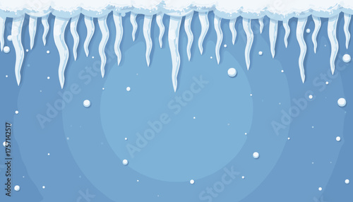 Icicles hanging from snow-covered roof with blue winter background  