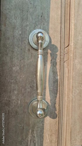 Metal door handle video on wooden surface in sunlight