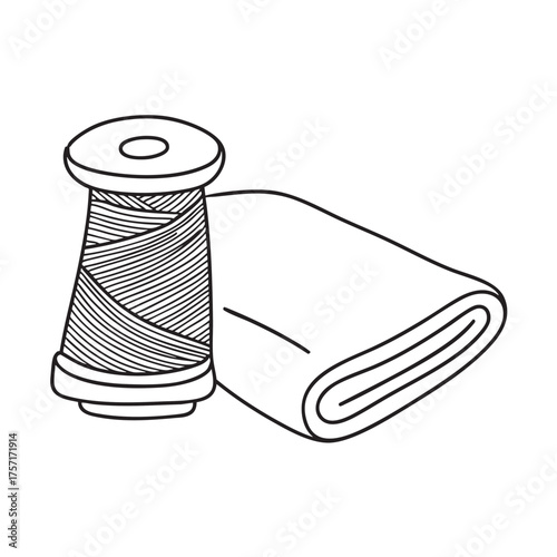 A spool of yarn close to a folded piece of fabric