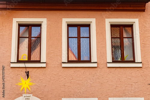 Exterior of an old Bavarian house from 1903 decorated with a Christmas star. Traditional German architecture and festive holiday atmosphere.