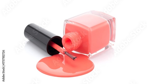 Coral nail polish spilled on a white surface, with bottle and brush