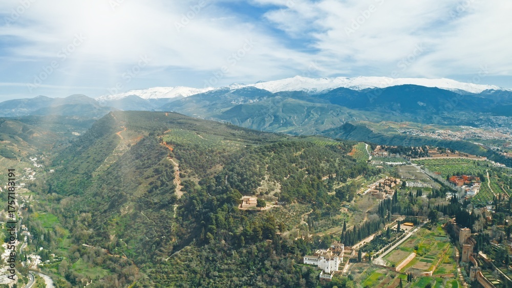 Obraz premium Drone flying aerial view Granada Sierra Nevada mountains landscape green hills blue skyline beautiful nature olive groves historic Alhambra travel Andalusian countryside Spanish tourism destination