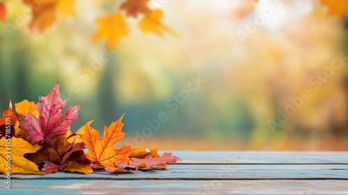 Vibrant burst of colorful autumn leaves in shades of orange red and yellow scattered on a wooden picnic table in a peaceful and serene natural landscape setting