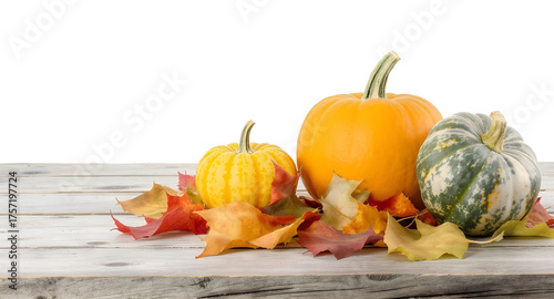 Autumn pumpkins and colorful fall leaves on a rustic wooden table