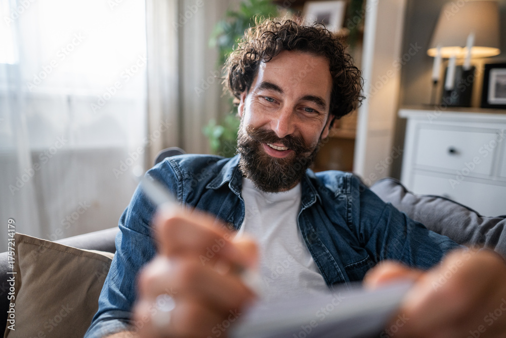 Naklejka premium Smiling man making online payment with credit card