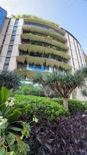 Building Facade Adorned with Climbing Plants and Lush Tropical Garden