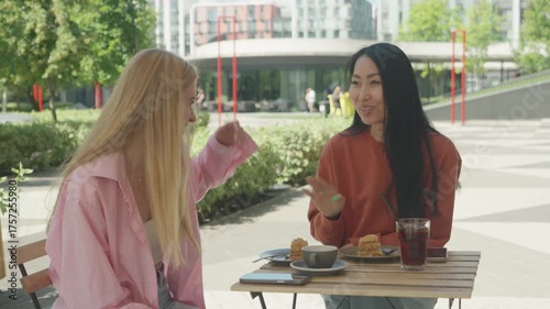 Two Happy Friends Laughing And Chatting At Modern Outdoor Coffee Spot