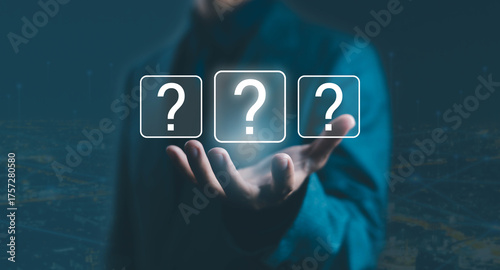 Businessman holding virtual question mark icons, symbolizing uncertainty, decision-making, problem-solving, and business strategy in digital technology and innovation for corporate planning.