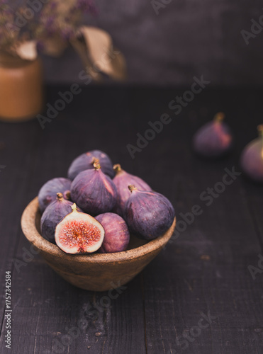 Half Sliced Fig in Wooden Bowl on Dark Wooden Surface
