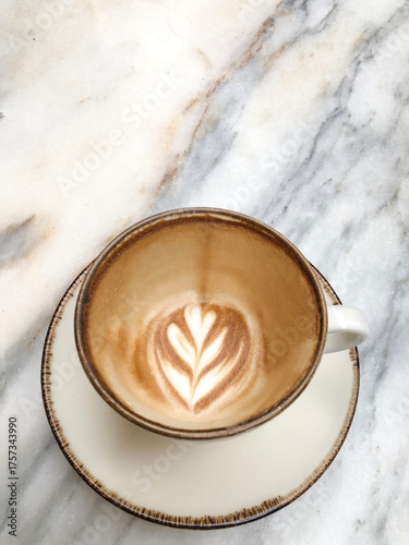 Empty coffee cup with remaining latte art foam on marble table after finished drink