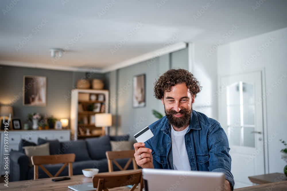Fototapeta premium Man shopping online using laptop and credit card
