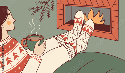 Feet in woollen socks by the Christmas fireplace. Woman relaxes by warm fire with a cup of hot drink and warming up her feet in woollen socks. Close up on feet. Winter and Christmas holidays concept.