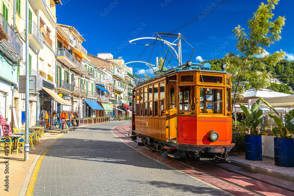 Naklejka premium Island of Mallorca. Colorful tramway links the inland town of Soller to Port de Soller, running along the beach-side road.