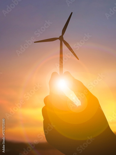 Hand Holding Wind Turbine Model at Sunset – Clean Wind Energy Concept