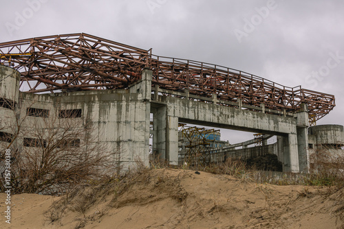 An abandoned building. The huge building, built of concrete and metal structures, is collapsing due to the effects of precipitation and erosion. Construction is frozen.