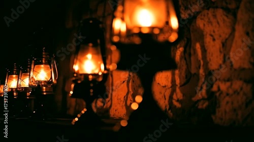 Warm glow of lanterns illuminating a stone wall in a dimly lit setting
