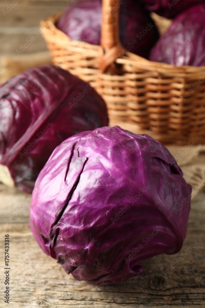 Fototapeta premium Whole ripe red cabbages on wooden table, closeup
