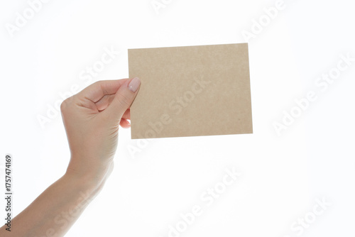 Woman's Hand Holding Blank Brown Kraft Paper Card on White Background