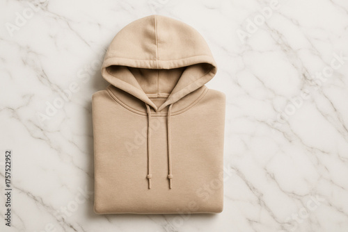 Minimalist folded beige hoodie on marble background fashion flat lay apparel design cozy streetwear clothing photography with soft texture and casual style