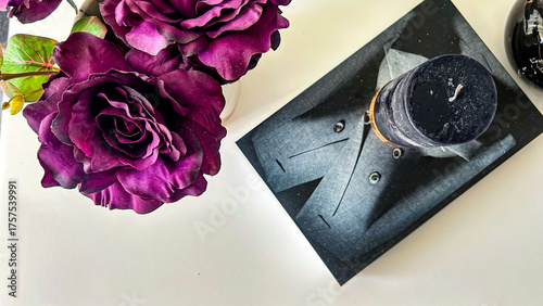 Obraz na plátně Dark Purple Roses And Black Candle On White Background Indoors, Concept Of Elega