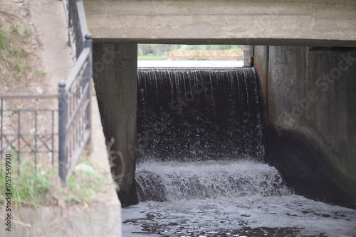 fast rushing waterfall under bridge