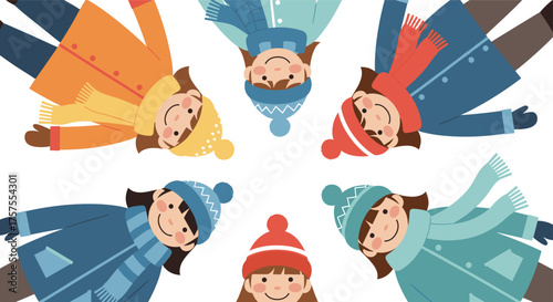 Children in winter clothes making snow angels together on a cold day in the snow.