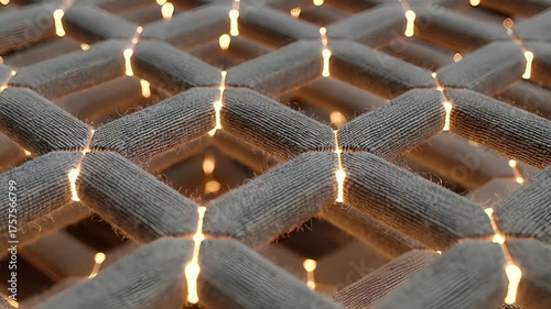 Close-up of a textured fabric grid with glowing lights, creating a warm ambiance