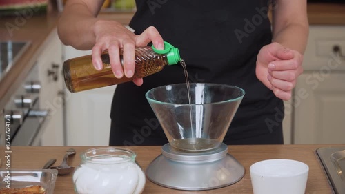 Pouring vinegar into glass bowl. Adding vinegar to transparent container. Dripping vinegar into clear dish